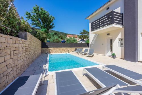 una piscina en el patio trasero de una casa en Villa BAŠKA near the beach, en Baška