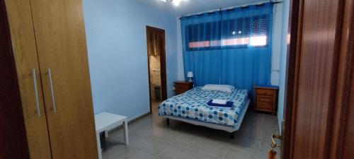a bedroom with a bed in a blue room at Los Cristianos centro, room with a private bathroom in shared apartment in Arona