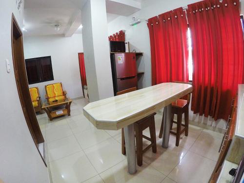 eine Küche mit einem Holztisch und einem roten Vorhang in der Unterkunft Bello-Oriente-II in Iquitos