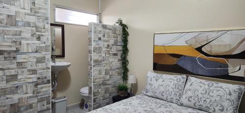 uma casa de banho com uma cama e um quadro na parede em Casa Altamira em San Pedro Sula