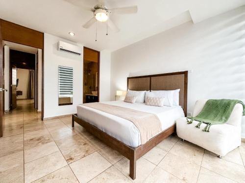 1 dormitorio con 1 cama y 1 silla en DC 1103 Trendy Condo in Mamitas beach area half block to 5th, en Playa del Carmen