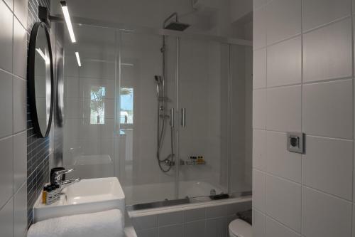 a white bathroom with a shower and a sink at Villa Per Mare in Maleme