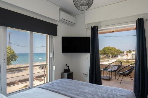 a bedroom with a bed and a view of the ocean at Villa Per Mare in Maleme