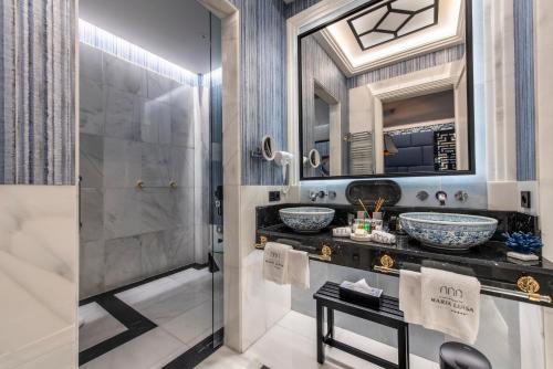 a bathroom with two sinks and a shower at Hotel Casa Palacio María Luisa in Jerez de la Frontera