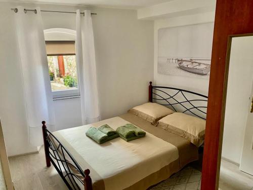 a small bed in a room with a window at Apartman Buccari in Bakar