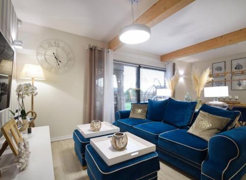 sala de estar con sofá azul y reloj en Domek Hampton Lubniewice jezioro, blisko spa, en Lubniewice