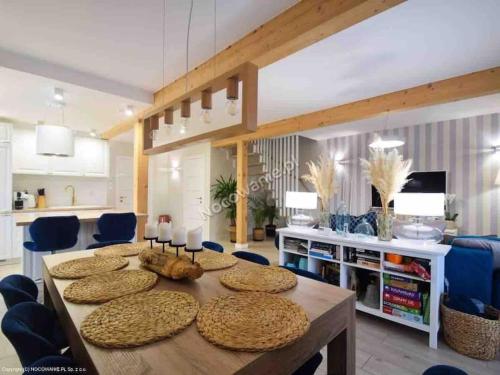 a living room with a table and blue chairs at Całoroczny Domek Hampton Lubniewice, jezioro, jacuzzi in Lubniewice