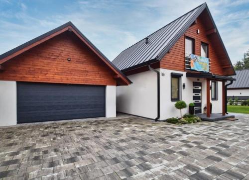 a house with a large garage at Całoroczny Domek Hampton Lubniewice, jezioro, jacuzzi in Lubniewice