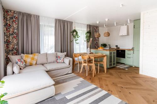 a living room with a white couch and a kitchen at Kurka Chata in Nowy Targ