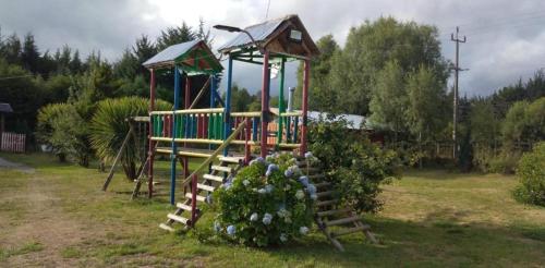 einen Spielplatz mit Rutsche im Hof in der Unterkunft Cabañas los Pinos in Villarrica