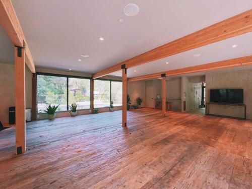 um quarto vazio com um quarto grande com pisos de madeira e uma televisão de ecrã plano em The Land - Luxury Retreat Center In Beautiful Nature - Bay Area Northern California em Philo