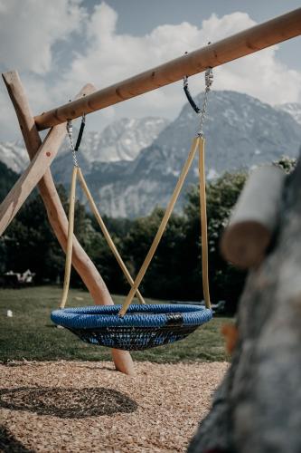 a swing hanging from a pole with mountains in the background at Alpenappartements Cristall in Ehrwald