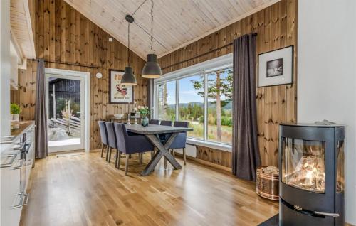 a dining room with a table and a fireplace at Nice Home In Gol With Wifi in Golsfjellet