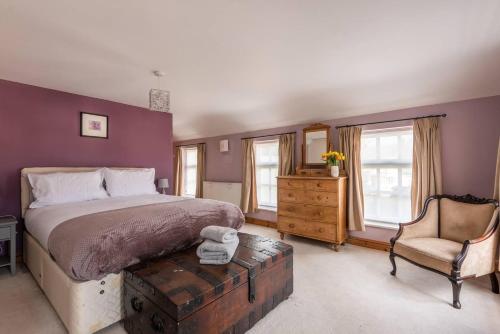 a bedroom with a large bed and a chair at Charming Chepstow Home in Chepstow