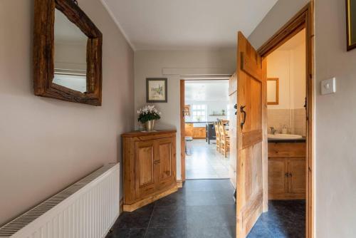 um corredor que leva a uma cozinha com um espelho e uma porta em Charming Chepstow Home em Chepstow