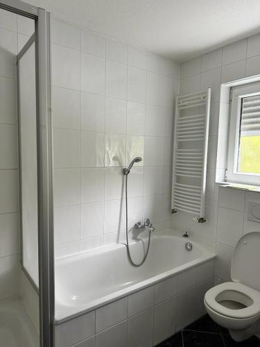 a bathroom with a bath tub and a toilet at Pension Seckbach in Frankfurt/Main