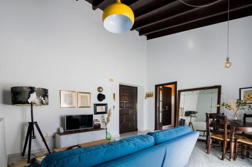 een woonkamer met een blauwe bank en een tafel bij Apartamento Historico Garaje y WIFI in Sanlúcar de Barrameda