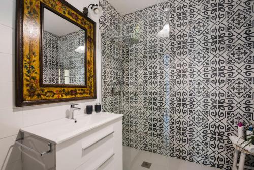 een badkamer met een spiegel en een witte wastafel bij Apartamento Historico Garaje y WIFI in Sanlúcar de Barrameda