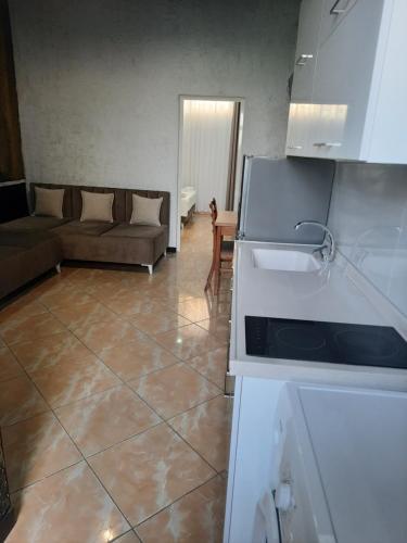 Il comprend une cuisine et un salon avec un canapé et une cuisinière. dans l'établissement VILA PUSHIMI REGIS, à Velipojë