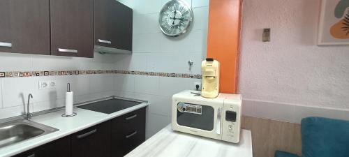a kitchen with a microwave on a counter with a clock at Mi Casita del Cabo in El Cabo de Gata