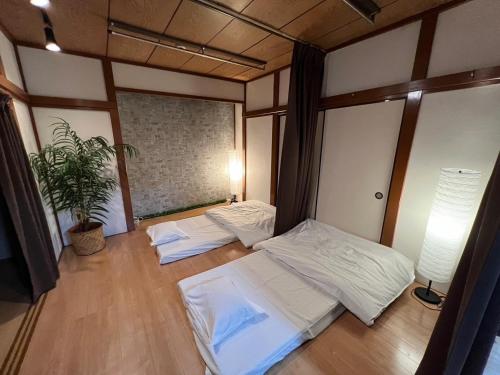 a room with two beds and a potted plant at SyunkaSyuutou - Vacation STAY 49643v in Hakone