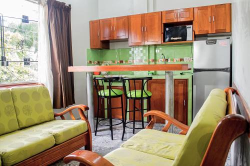 eine Küche mit einer Bar und einer grünen Küche in der Unterkunft Bello-Oriente-I in Iquitos