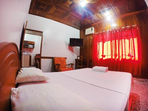 ein Schlafzimmer mit 2 Betten und einem roten Vorhang in der Unterkunft Bello-Oriente-I in Iquitos