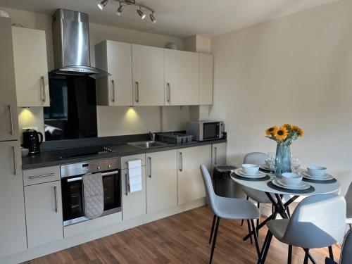 a kitchen with white cabinets and a table with chairs at Cambridge Apartment with free onsite parking in Cambridge