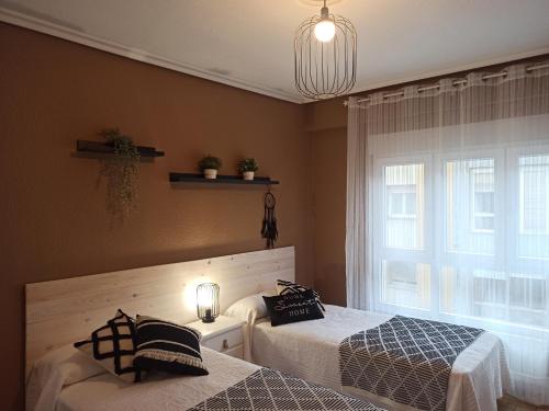 a bedroom with two beds and a window at Piso céntrico Calma Costera in Santander