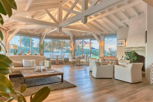 a living room with white furniture and large windows at Villa L'Arche in Bidart