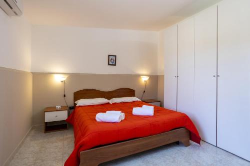 a bedroom with a red bed with two towels on it at Oasi lamia - 3 in Mazara del Vallo