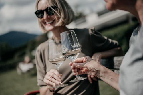 two people holding wine glasses in their hands at Alpenappartements Cristall in Ehrwald