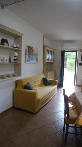 sala de estar con sofá amarillo en una habitación en Rocca Cilento B&B, en San Martino