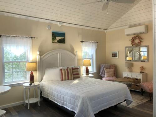 Cape cottage inn في كيب ماي: غرفة نوم بسرير ابيض كبير وحمام