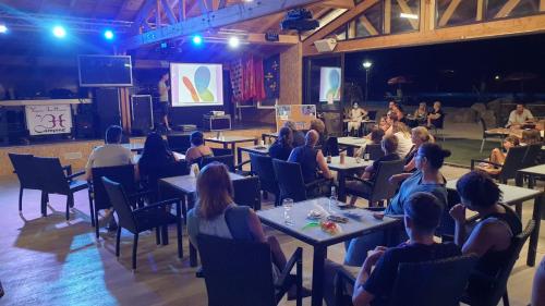 a group of people sitting at tables in a room at Camping Le Pré Cathare in Lavelanet