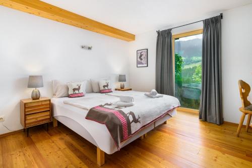 a bedroom with a large bed and a window at Chalet Mora-lodge by Alpine Host Helpers in Kitzbühel