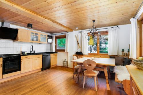 una cucina con soffitto in legno e tavolo con sedie di Chalet Mora-lodge by Alpine Host Helpers a Kitzbühel