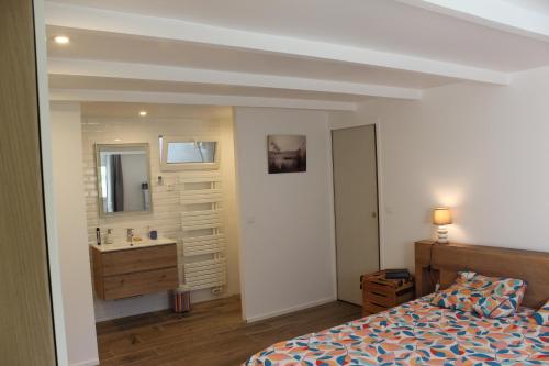 a bedroom with a bed and a bathroom with a sink at Maison La Rascasse in Rayol-Canadel-sur-Mer