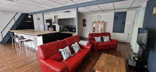 a living room with a red couch and a kitchen at Loft tout équipé 7 personnes in Hazebrouck