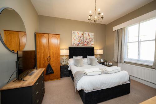a bedroom with a large bed and a mirror at The Bramley House Hotel in Chatteris