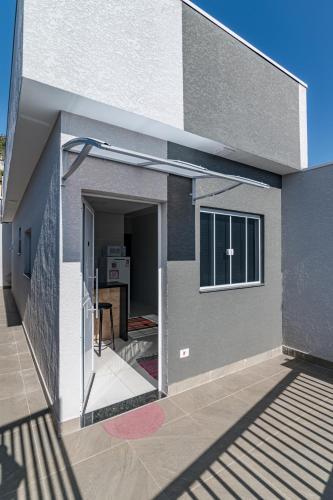 a house with a door open to a patio at Pousada Casa da Cidinha in Extrema