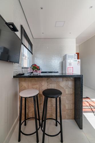 a kitchen with two stools in front of a counter at Pousada Casa da Cidinha in Extrema