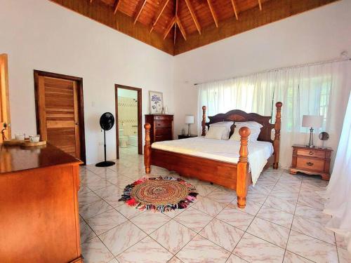 a bedroom with a bed and a large window at The Happy Retreat Villa in Belmont, Jamaica in Blue Hole
