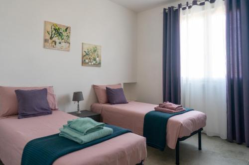 a room with two beds and a window at Residence Pace & Relax in Marina di Grosseto