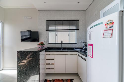 a small kitchen with a sink and a refrigerator at Pousada Casa da Cidinha in Extrema