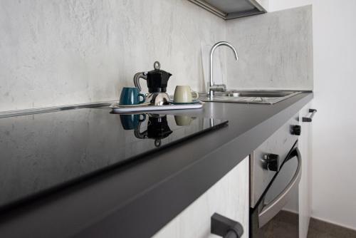 a kitchen counter with a sink and a tea kettle at Residence Pace & Relax in Marina di Grosseto