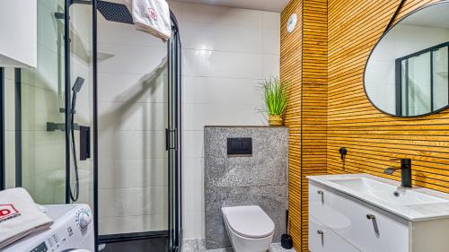 ein Badezimmer mit einem WC, einem Waschbecken und einem Spiegel in der Unterkunft Apartament Malachit Osada Górska z prywatną sauną - 5D Apartamenty in Szklarska Poręba
