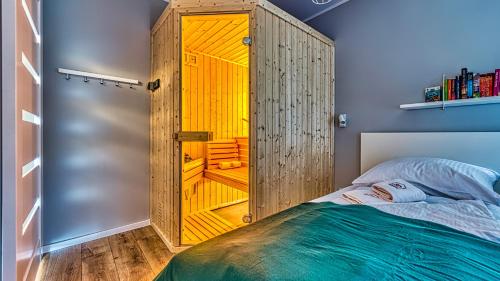 ein Schlafzimmer mit einem großen Holzschrank neben einem Bett in der Unterkunft Apartament Malachit Osada Górska z prywatną sauną - 5D Apartamenty in Szklarska Poręba