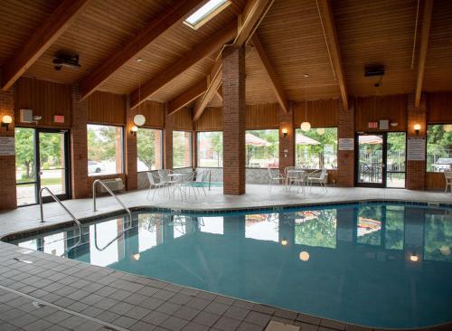 a large swimming pool in a building with windows at Lomira Inn and Suites in Lomira