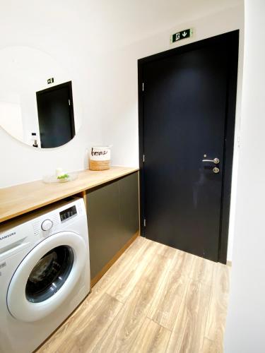 a bathroom with a washing machine and a mirror at Magdalena Suite 3.0 in Heraklio Town